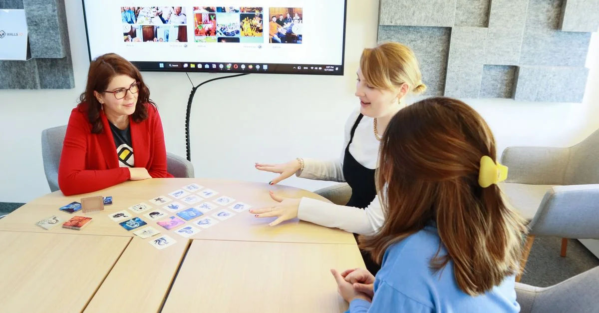 Trois femmes discutent d'idées dans un bureau moderne, s'engageant dans le travail d'équipe et la collaboration.