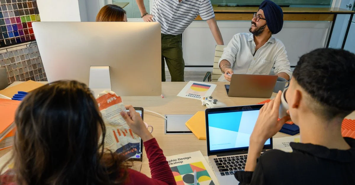 Un groupe de professionnels divers collabore sur un projet de design dans un cadre de bureau moderne.